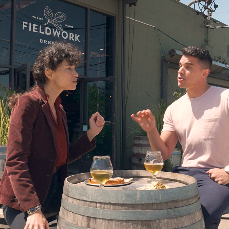 Two friends drink together outside Berkeley's Fieldwork Brewery